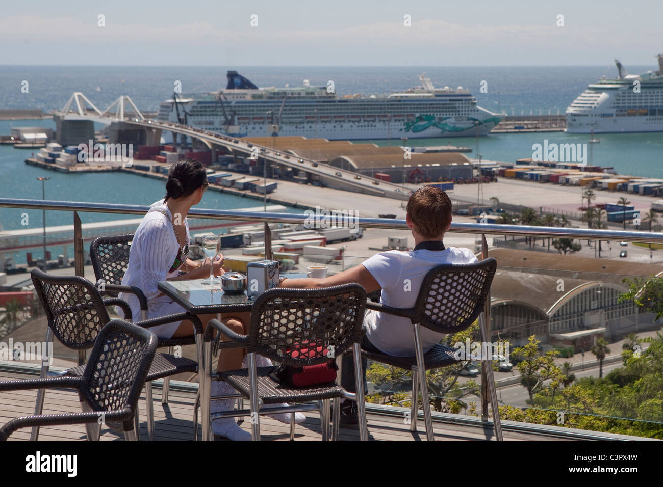 Un paio di avere un drink mentre guarda al porto di Barcellona. Foto Stock