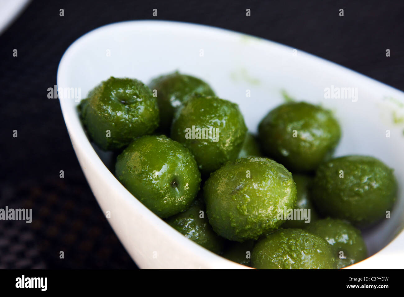 Bright Green Olive in bianco ciotola ovale Foto Stock