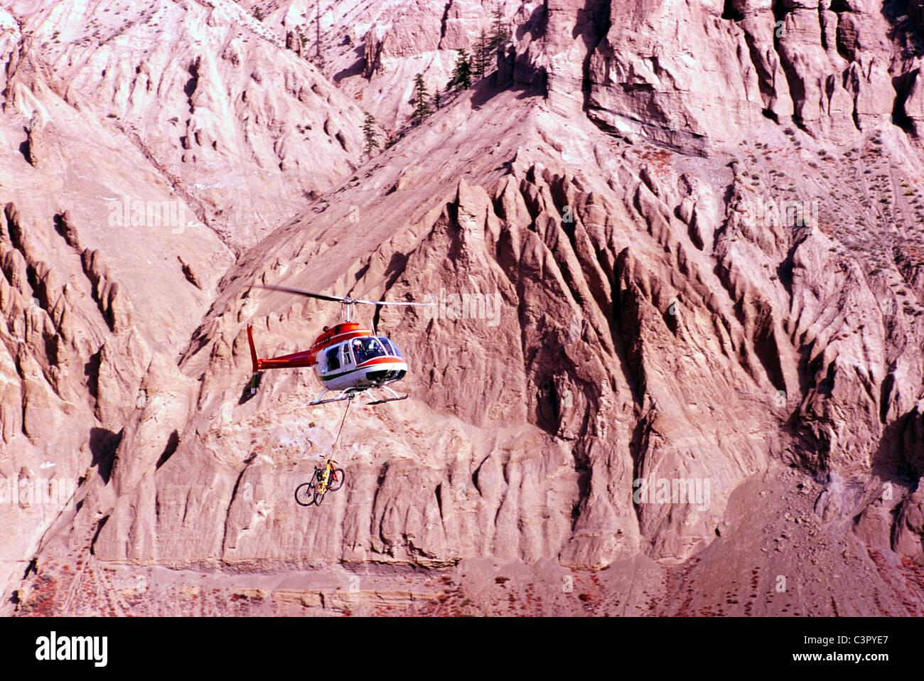 Gli sport estremi, elicottero volando Mountain Bikes per Cliff Mountain Bike in Farewell Canyon, Regione Cariboo, British Columbia, Canada Foto Stock