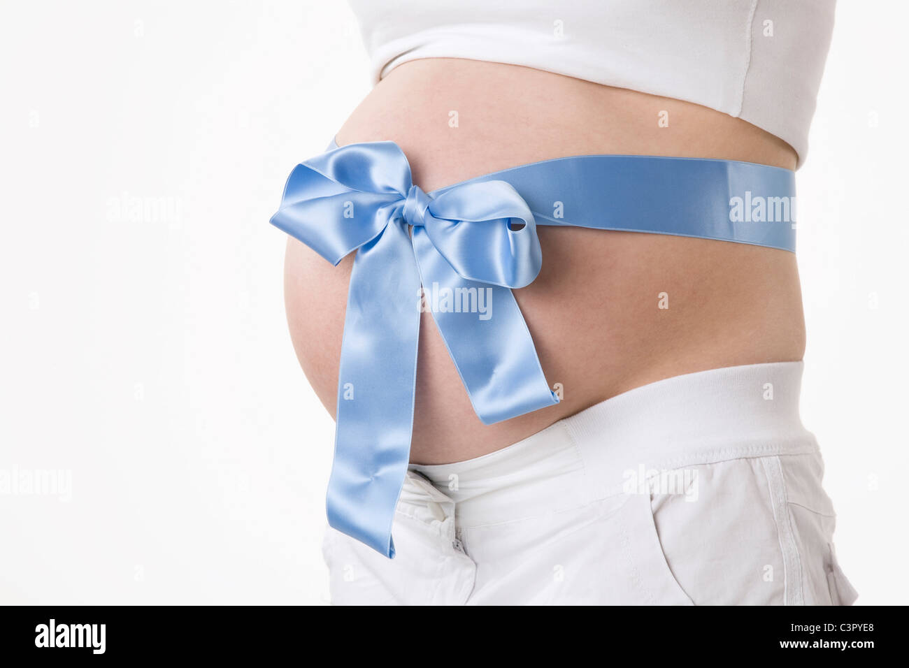 Donna incinta con nastro blu attorno al ventre, metà sezione Foto Stock