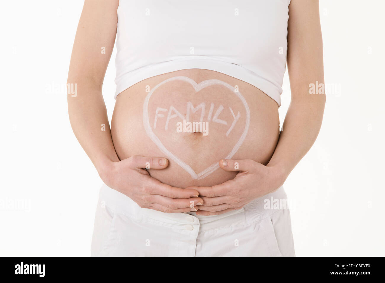Forma di cuore disegnato sulla donna incinta il ventre, metà sezione Foto Stock