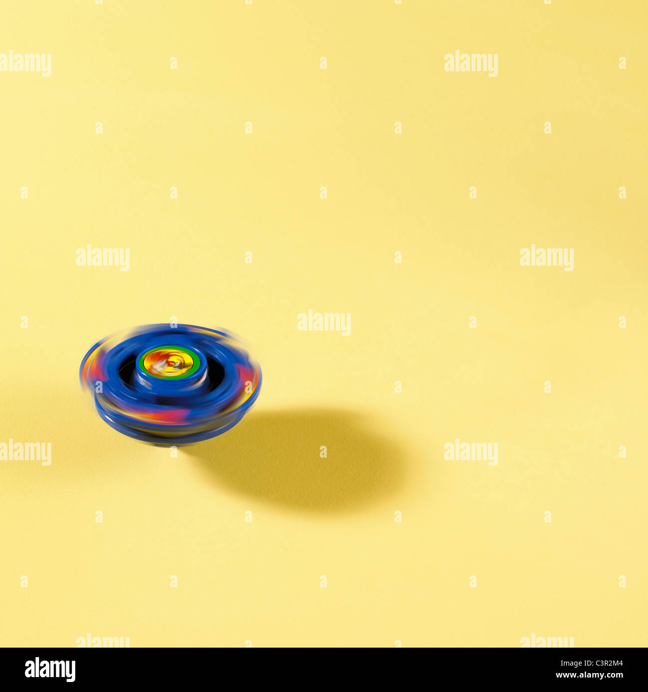 Pegtop spinner la filatura su sfondo giallo Foto Stock