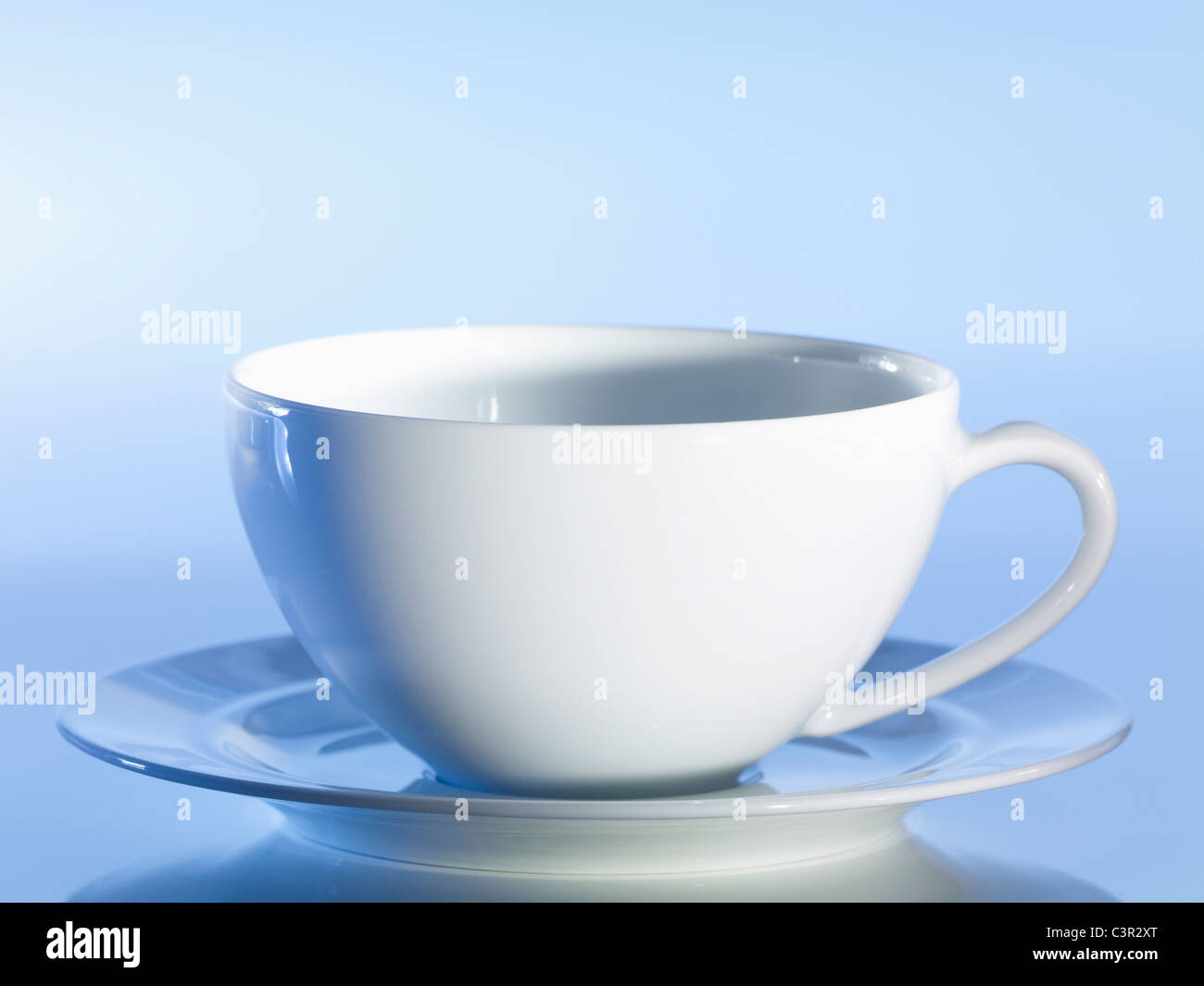 Svuotare tazza da caffè con piattino contro sfondo blu, close-up Foto Stock