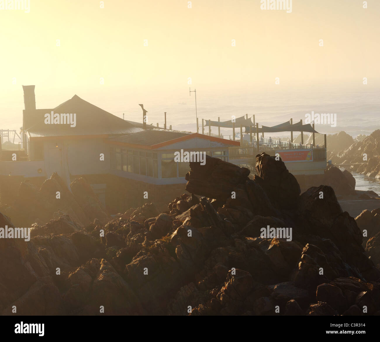 Ristorante sulle rocce al Point Hotel con misty sunrise, Mossel Bay, Provincia del Capo, in Sud Africa Foto Stock