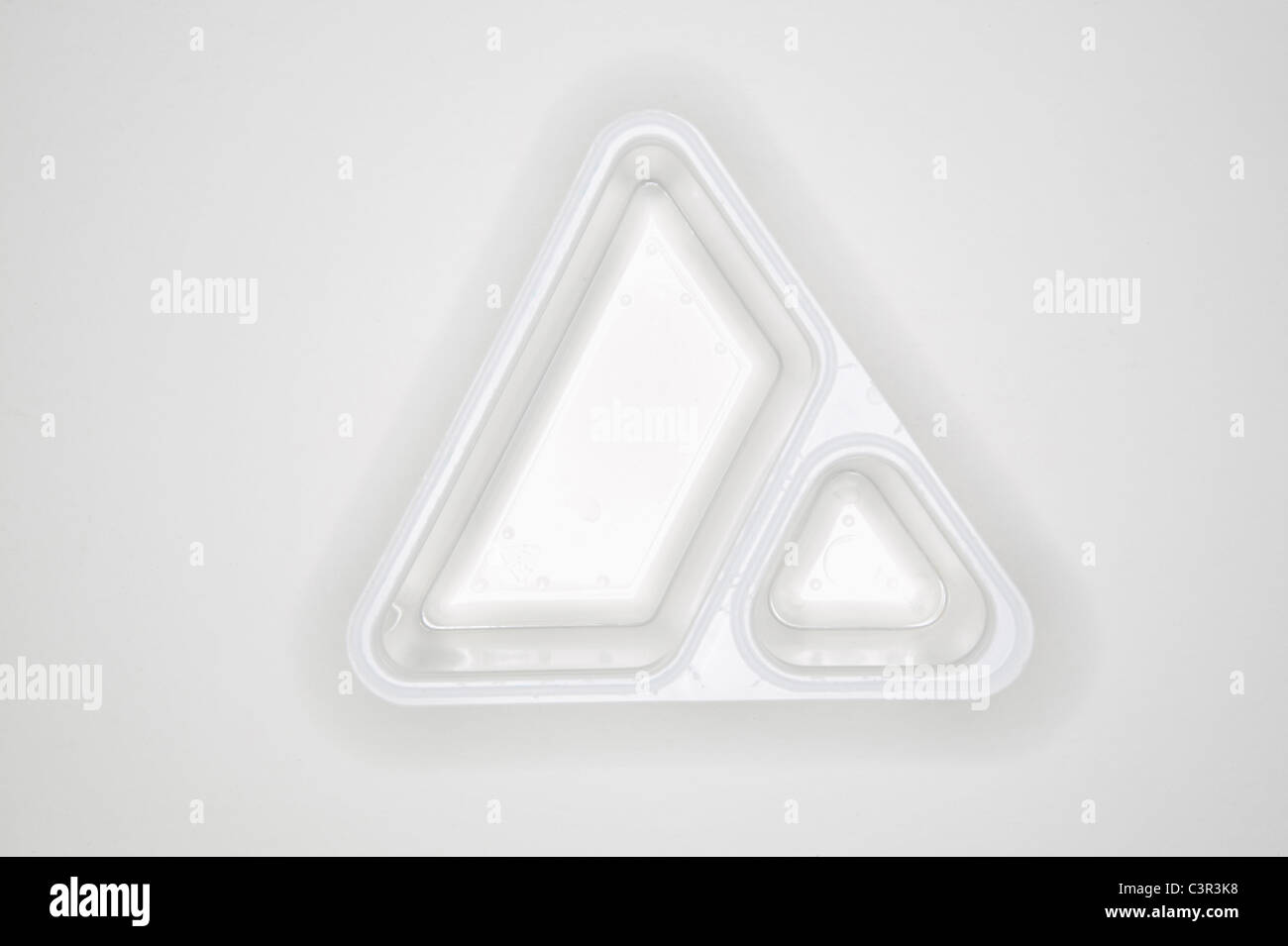 Forma di triangolo contenitore in plastica su sfondo grigio Foto Stock