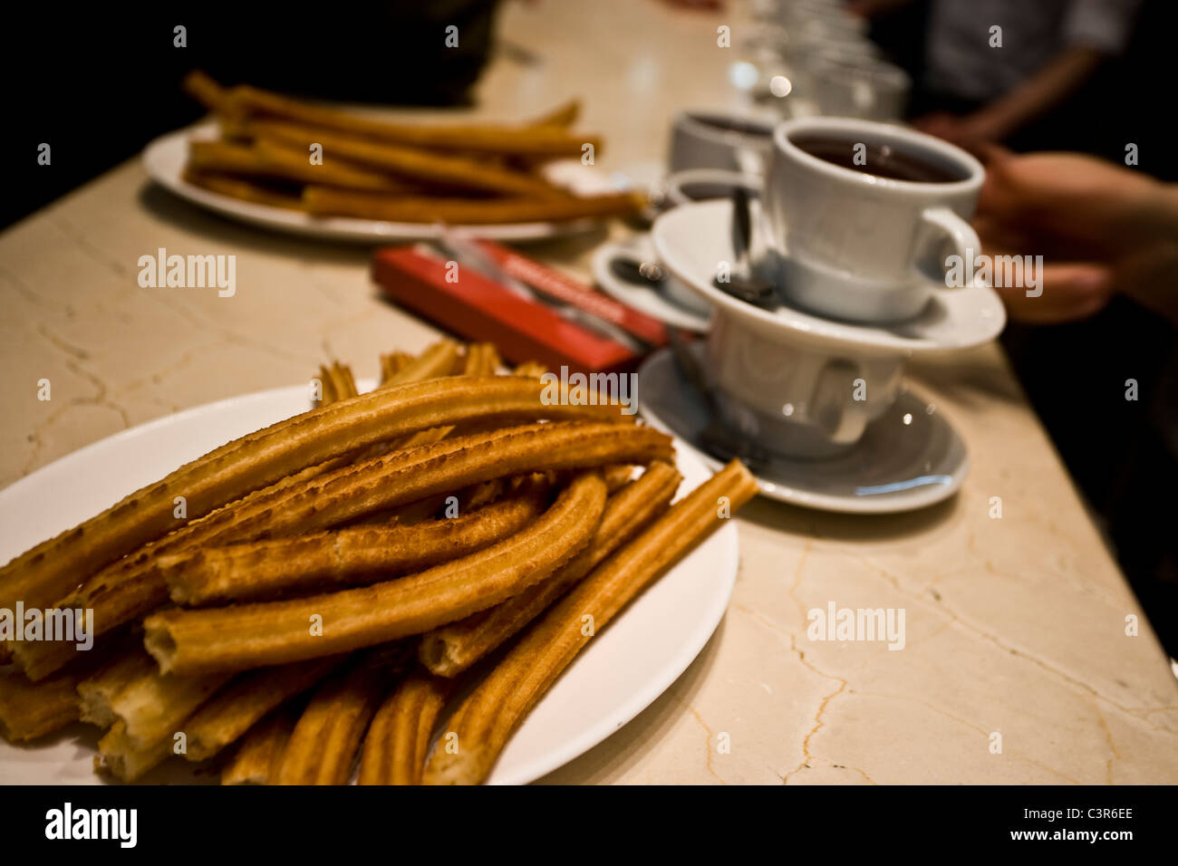 6:35 AM: "Cioccolato con churros', un tradizionale spagnolo brealfast, pronta per essere servita a San Ginés, in Madrid. Foto Stock