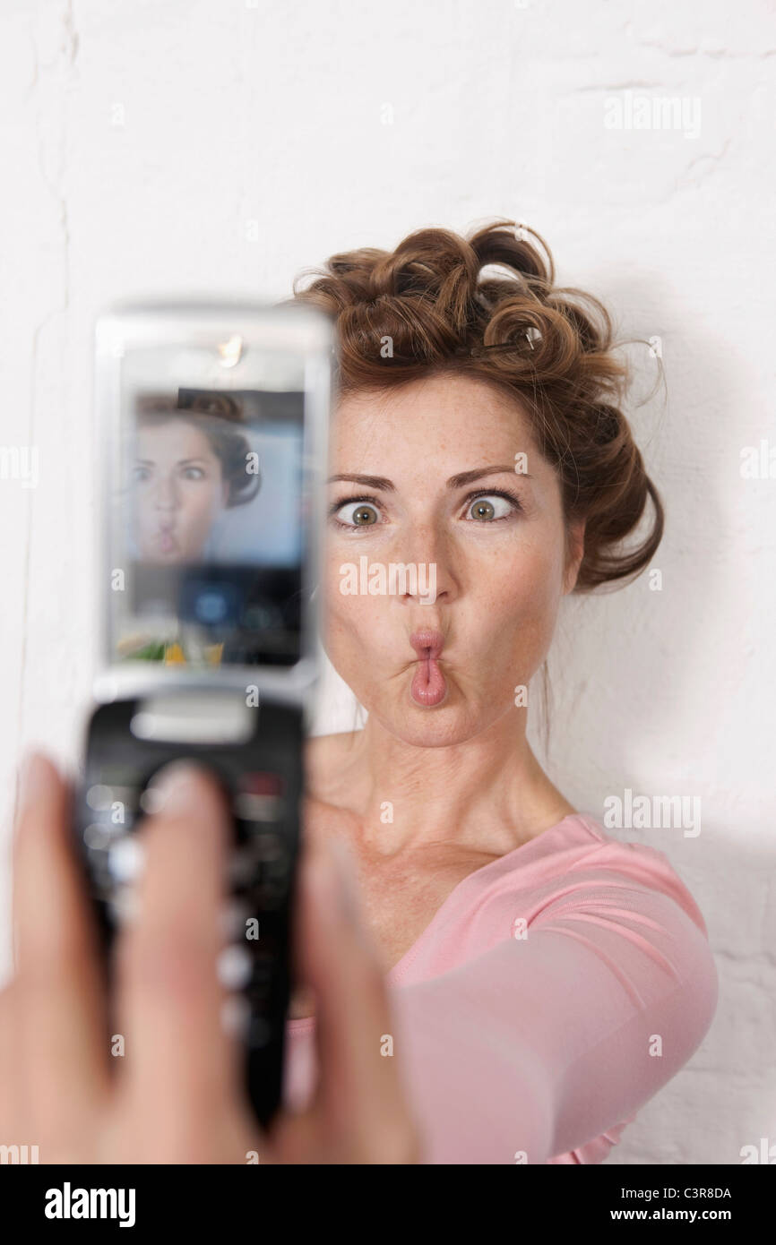 Germania, Donna Fotografa se stessa con un telefono cellulare Foto Stock