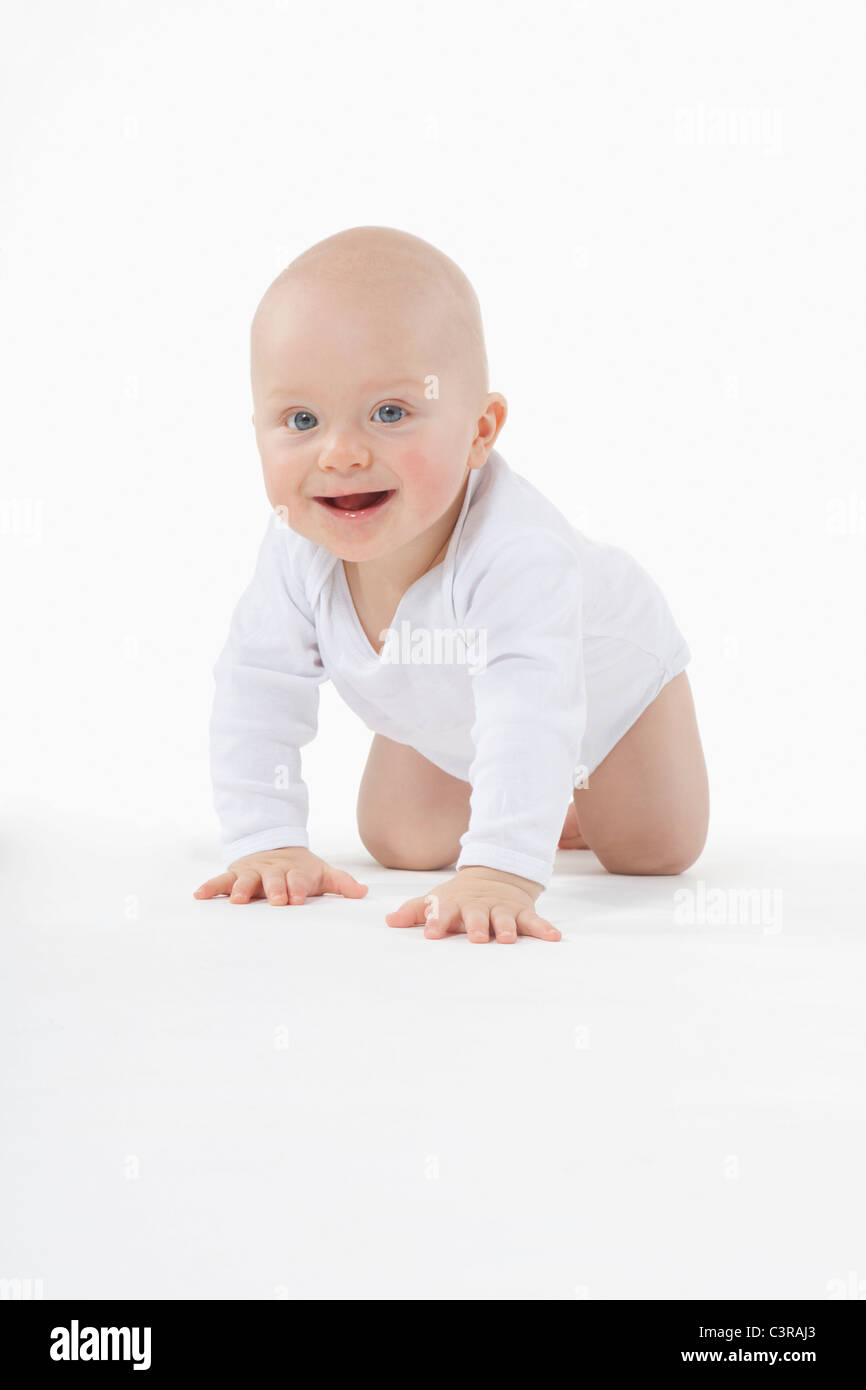 Baby boy (6-11 mesi) gattona, sorridente Foto Stock