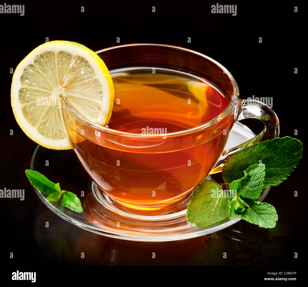 Tazza di tè alla menta e limone isolata su uno sfondo nero. Foto Stock