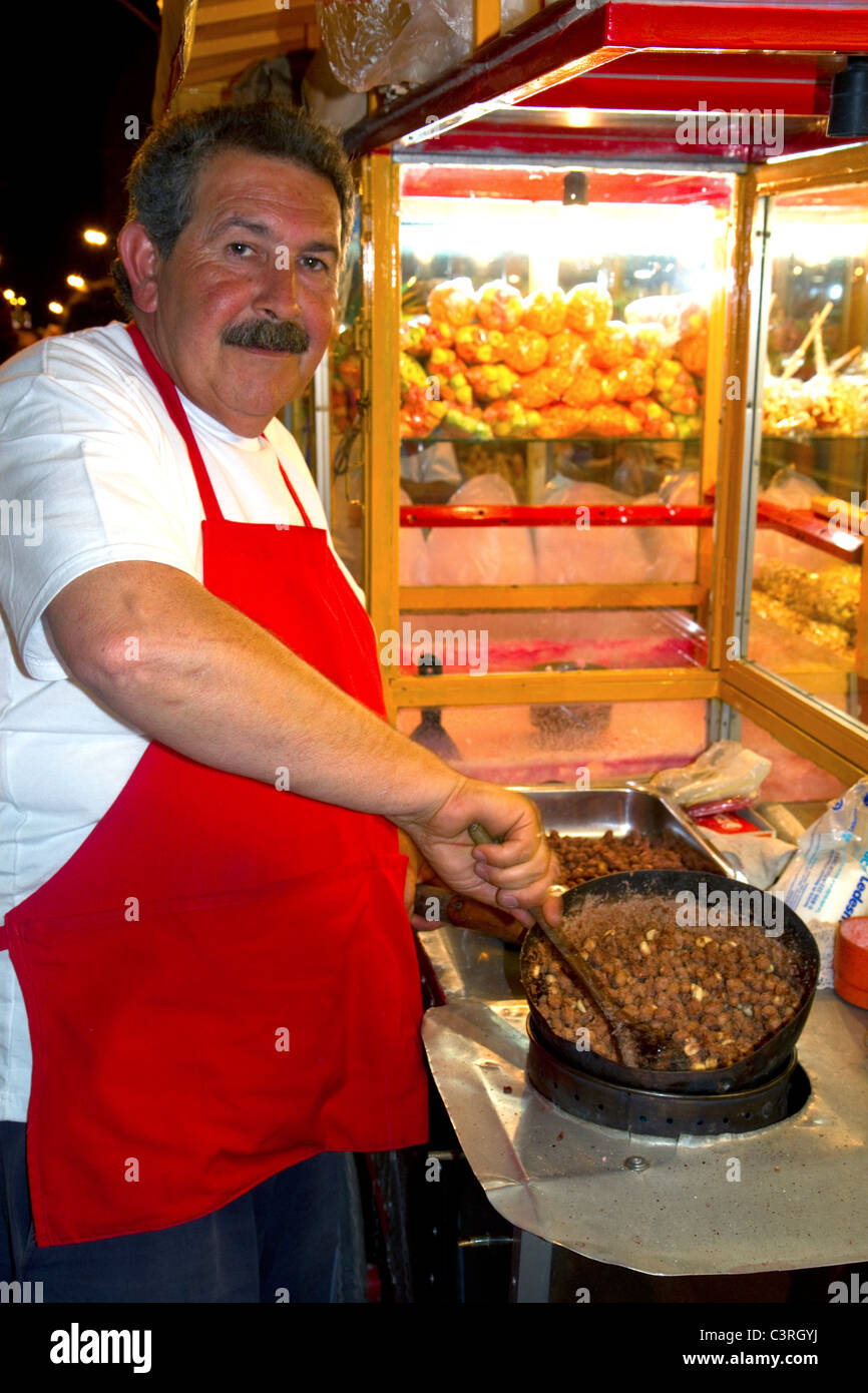 L'argentino venditore ambulante rendendo toffee coperto i dadi a Necochea, Argentina. Foto Stock