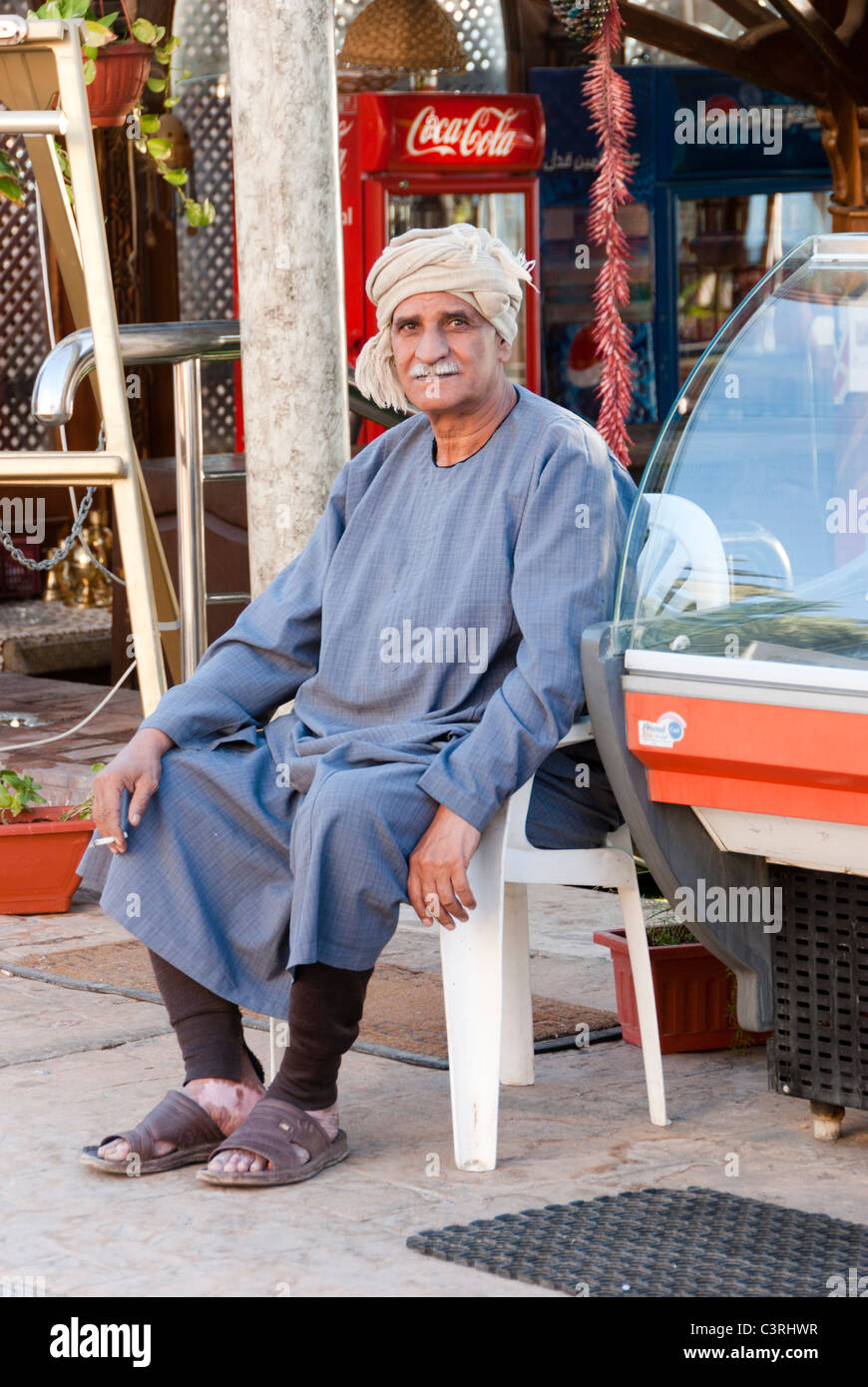 Egyptian uomo seduto su una sedia e fumatori - Dahab, la penisola del Sinai - Egitto Foto Stock