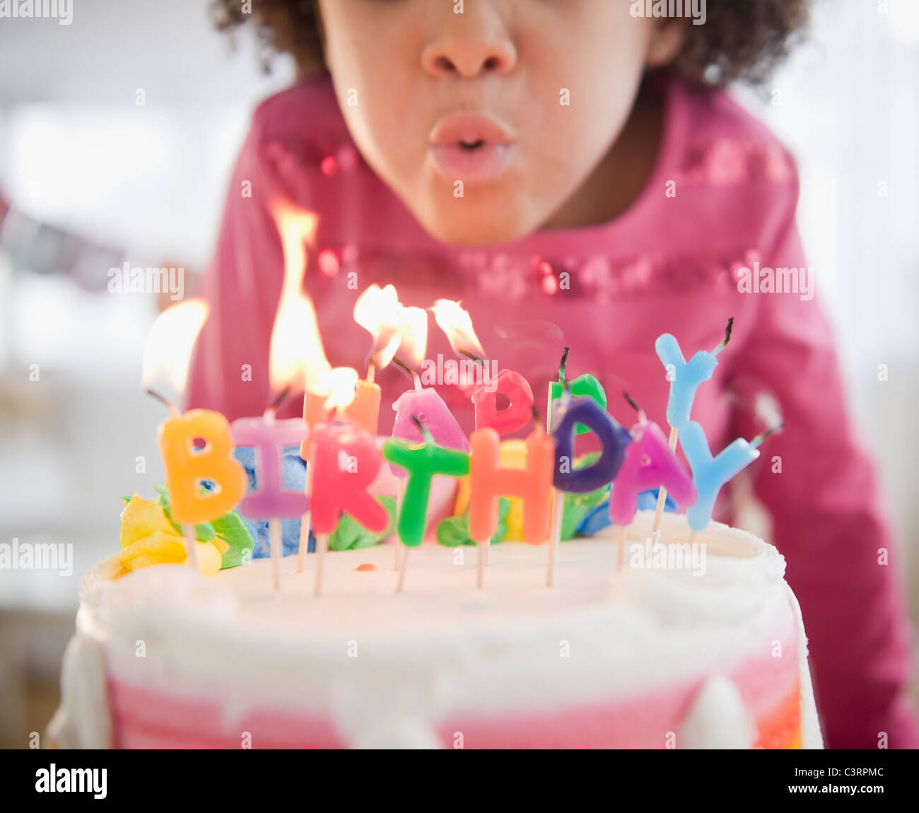 African American Girl che spegne le candeline sulla torta del compleanno Foto Stock