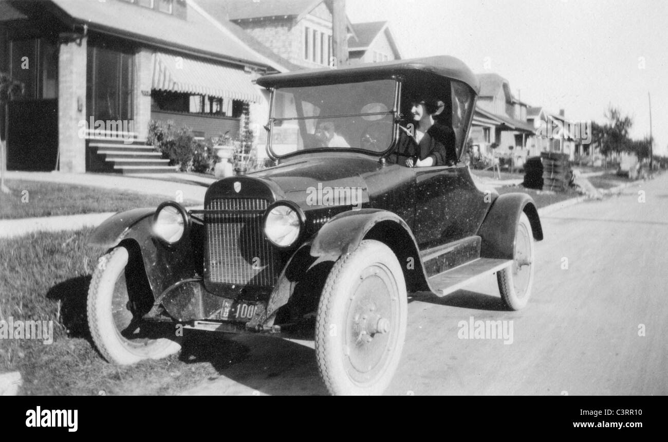 Una donna guarda fuori da un 1920s coupe Auto. automobile case vintage 20s alla moda di antiquariato Foto Stock