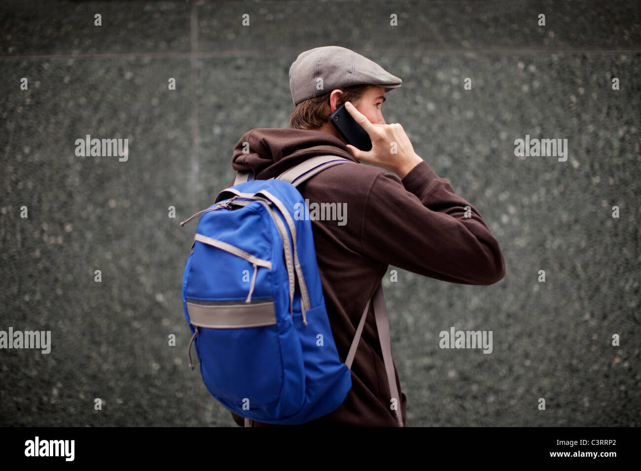 Uomo caucasico nello zaino parlando al cellulare Foto Stock