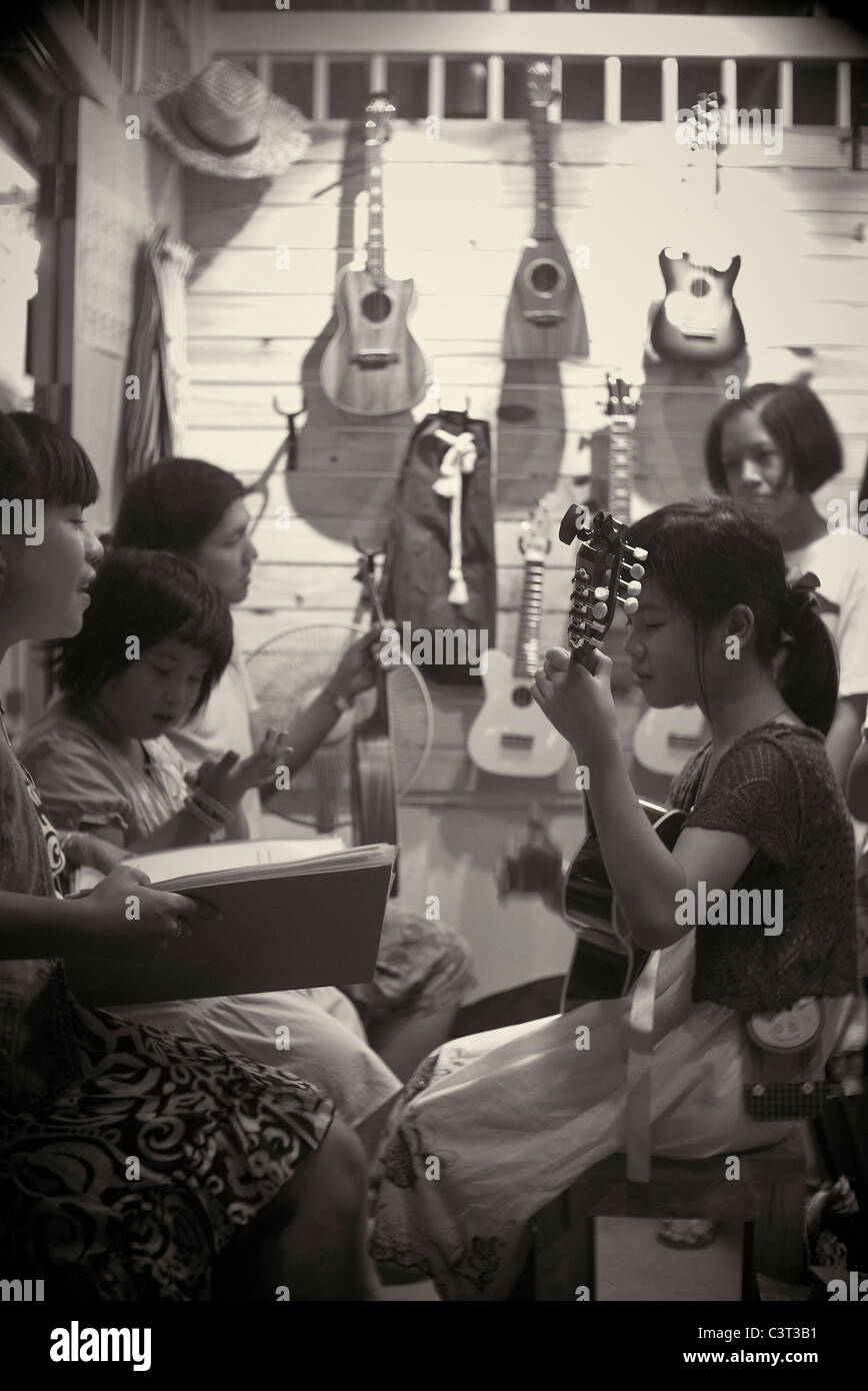 Immagine moderna elaborati come un'annata fotografia di un vecchio tempo di incontro familiare e sessione musicale. Thailandia Sudest Asiatico la fotografia in bianco e nero Foto Stock