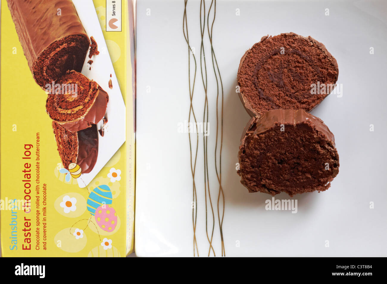 Scatola di Sainsbury's Pasqua log di cioccolato con due fette sulla piastra - cioccolato laminati in spugna con crema di burro al cioccolato e ricoperta di cioccolato al latte Foto Stock