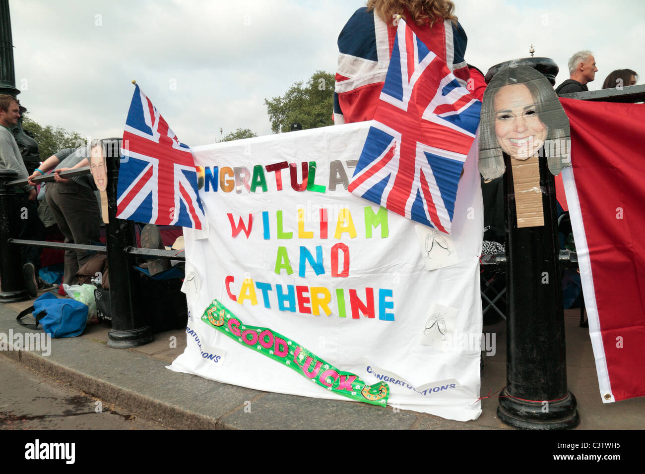 Banner attaccata alla ringhiera fuori Buckingham Palace la notte prima del matrimonio regale del principe William e Kate Middleton. Foto Stock