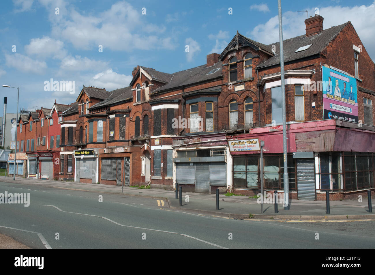 Fila di negozi terrazzati Princess Road,Moss Side,Manchester. Foto Stock