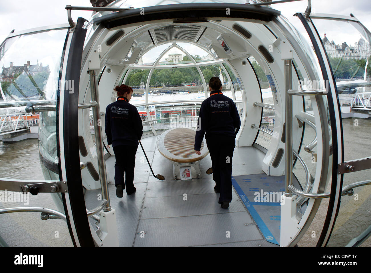 Due del personale di sicurezza controllando uno del London Eye capsule prima del pubblico sono autorizzati a entrare. Foto Stock