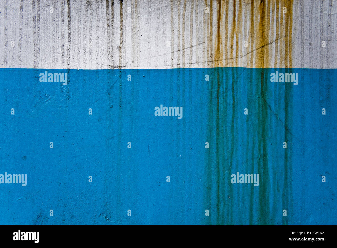 Il risultato di gocciolare la ruggine-ridden acqua rimane su una parete dipinta. Foto Stock