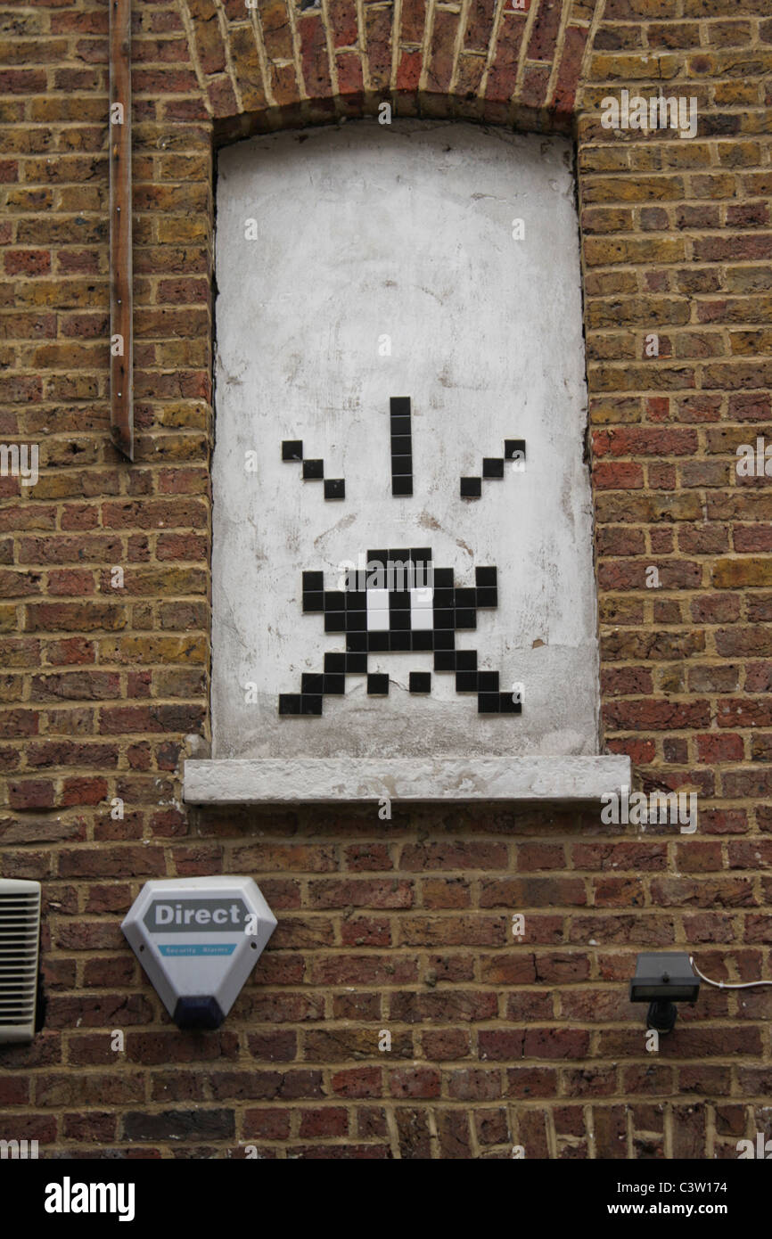 Invader è un anonimo artista di strada francese. È noto per i suoi mosaici di piastrelle in ceramica modellati sull'arte pixelata del videogioco a 8 bit degli anni '1970-1980 Foto Stock
