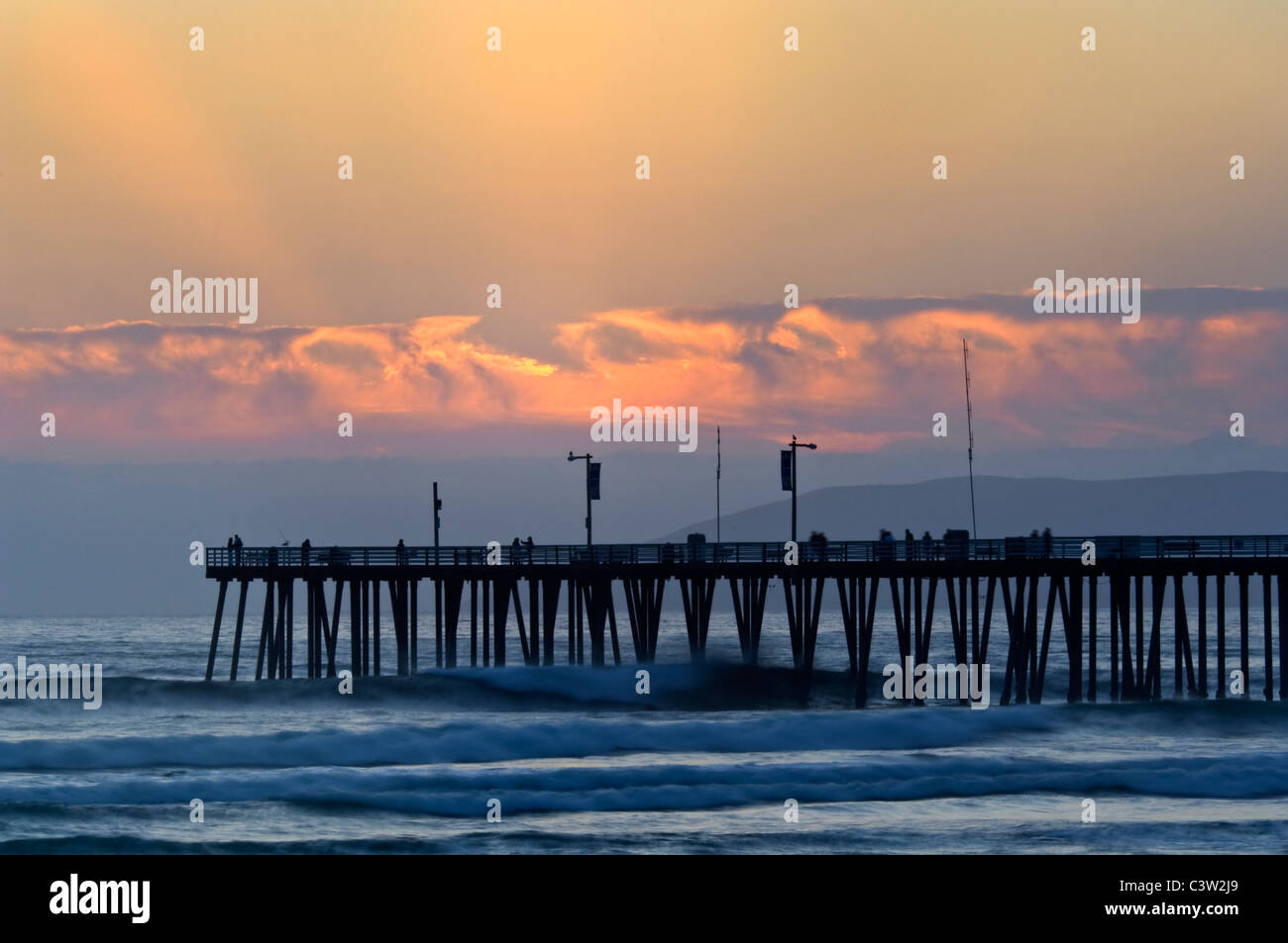 La luce del tramonto sul molo e oceano onde a Pismo Beach, San Luis Obispo County costa, California Foto Stock