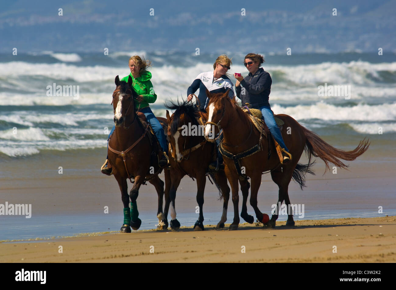 Tre giovani donne a cavallo sulla sabbia a stato Oceano Beach, Oceano, California Foto Stock
