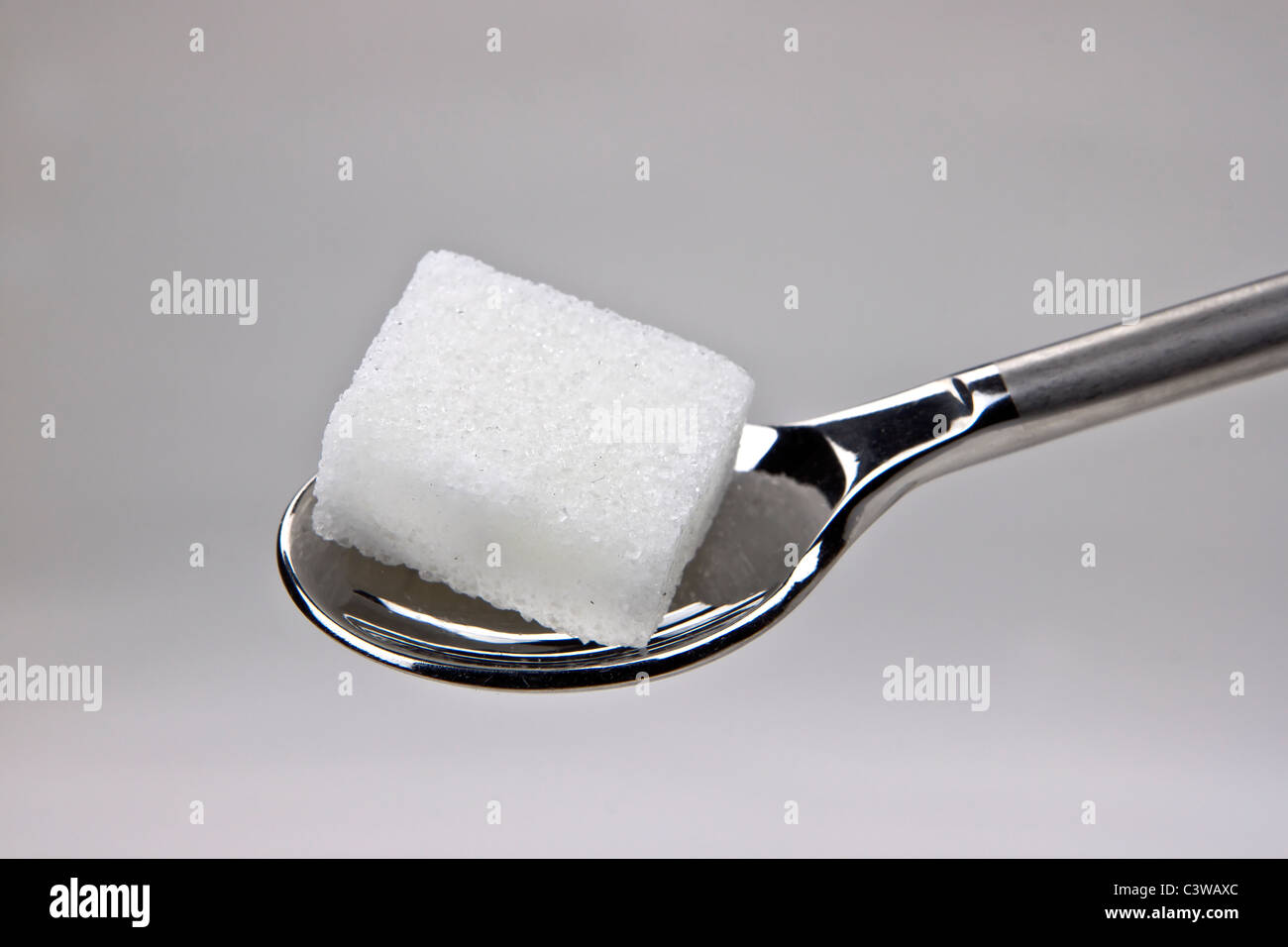 Pezzo di cubetti di zucchero su un cucchiaio Foto Stock