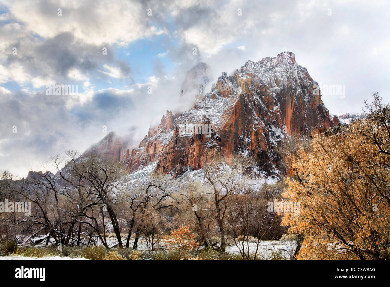 Un rude picco di montagna e in inverno la neve oltre il fiume vergine su un burrascoso giornata al Parco Nazionale di Zion, Utah, Stati Uniti d'America Foto Stock