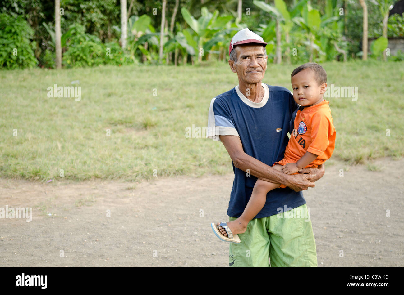 Vecchio con bambino in Bali Indonesia village Foto Stock