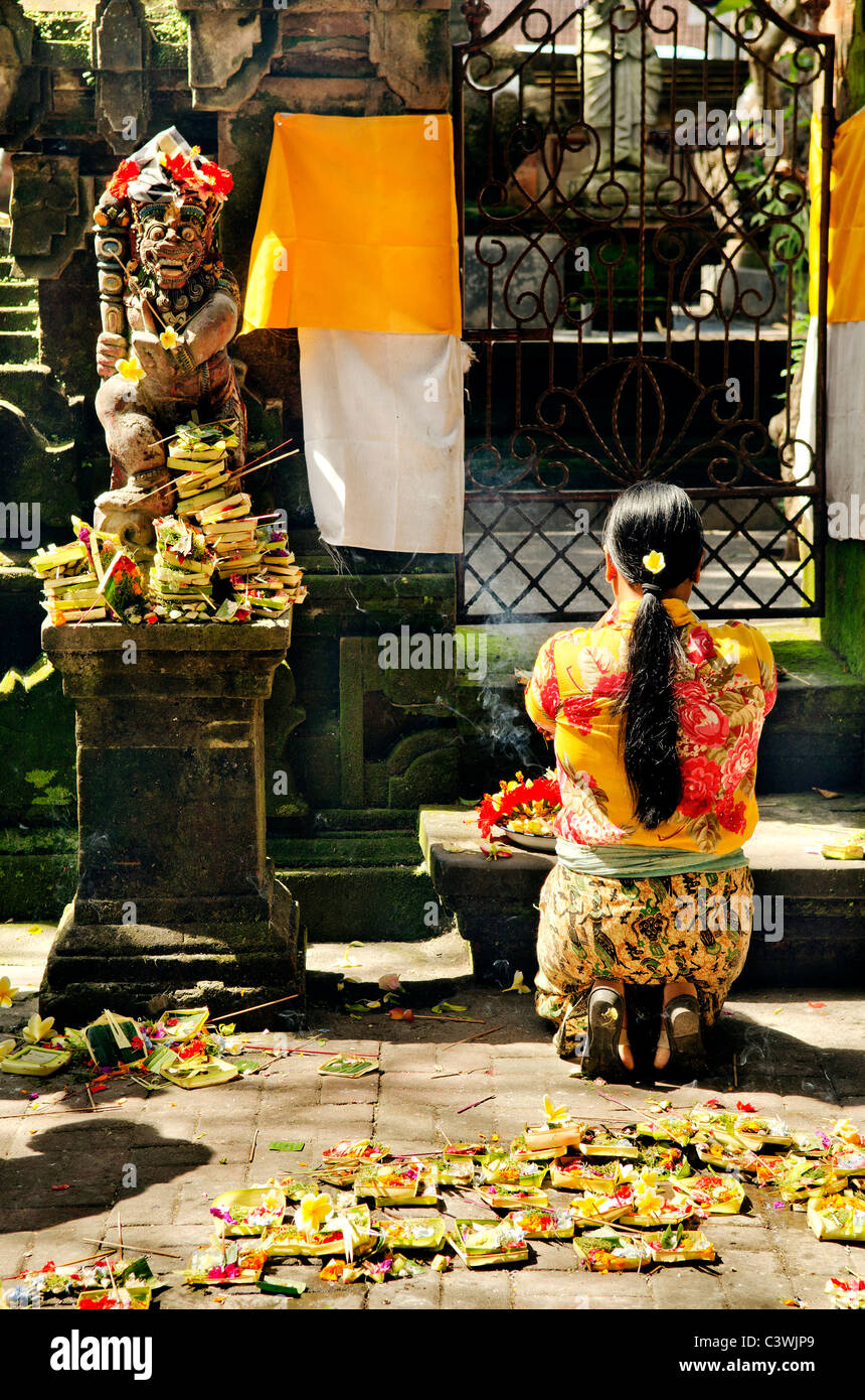 Donna che prega nel tempio Bali Indonesia Foto Stock