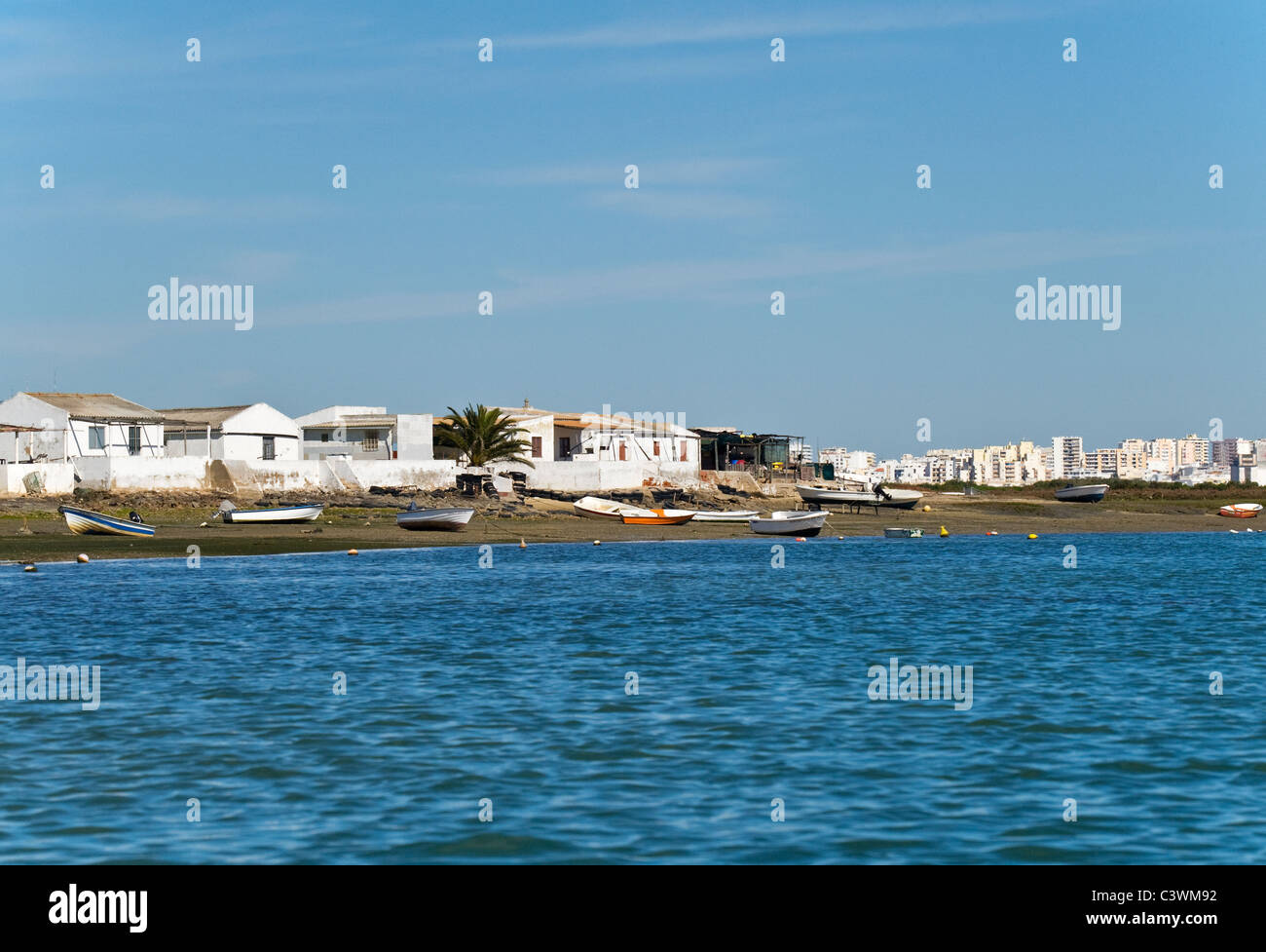 Case di pescatori su Ria Formosa con faro in background , , Algarve Portogallo Foto Stock