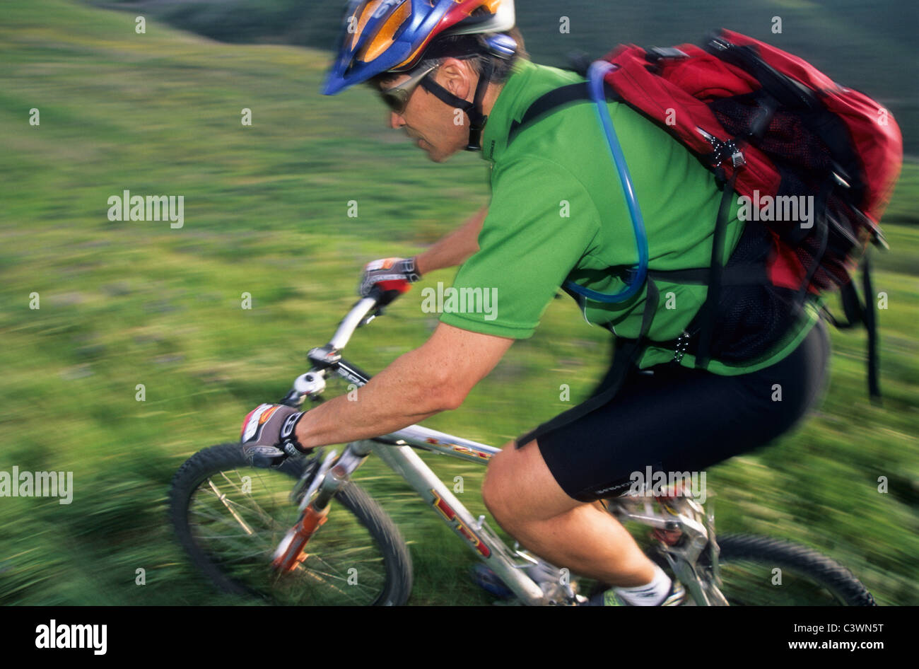 Uomo a cavallo in mountain bike attraverso le erbe. Foto Stock