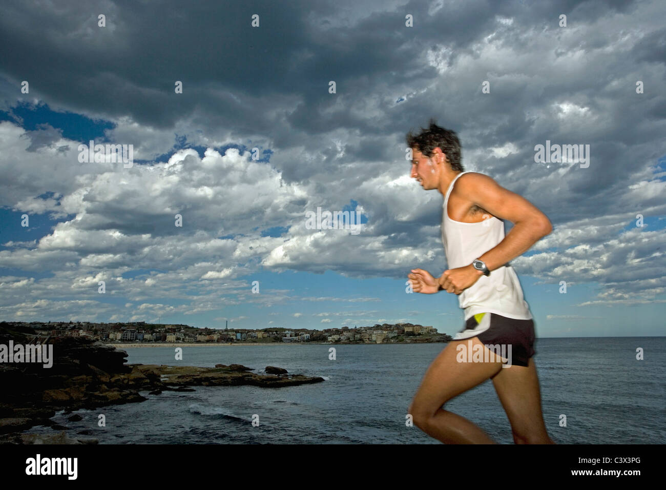 Australia, Sydney, uomo jogging sulla spiaggia Bondi. Foto Stock