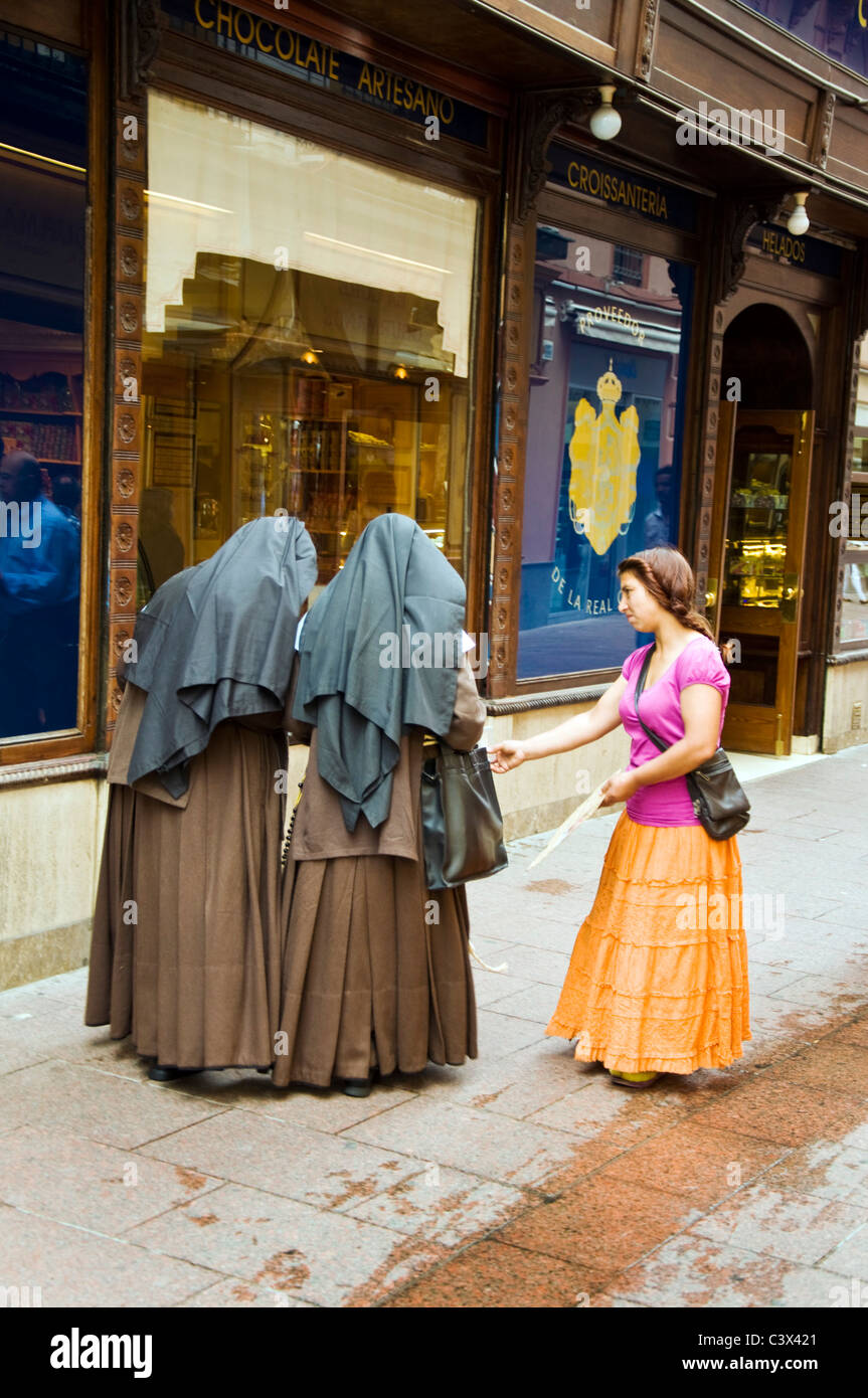 In Sierpes siviglia Spagna a Roma la donna chiede soldi da due monache come spagnolo morsi di recessione Foto Stock