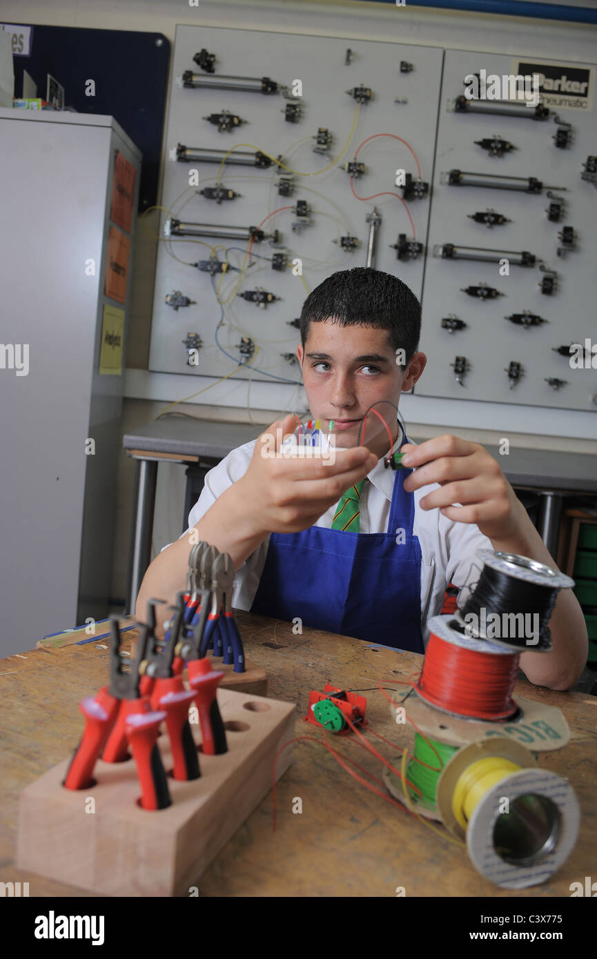 Un ragazzo durante una lezione di GCSE apprendimento pratico circa l'elettronica e la tecnologia di progettazione Foto Stock