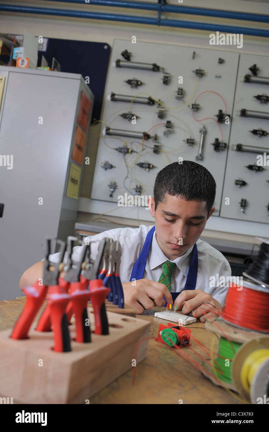 Un ragazzo durante una lezione di GCSE apprendimento pratico circa l'elettronica e la tecnologia di progettazione Foto Stock