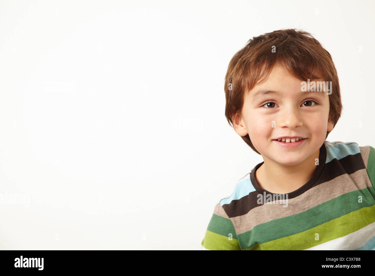 Giovane ragazzo sorridente su sfondo bianco Foto Stock