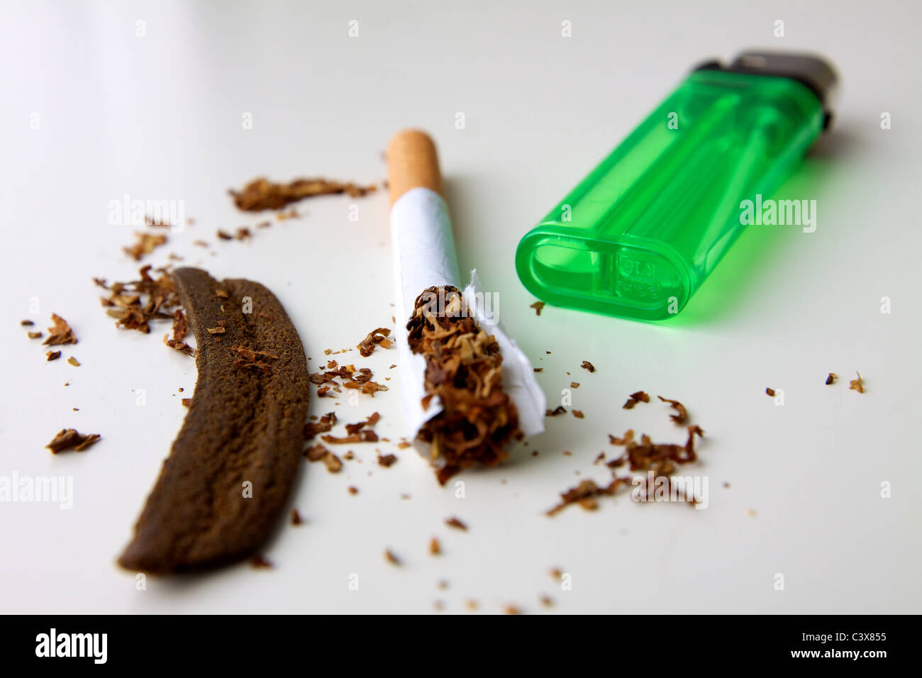 Hashish marocchino o hash, una sigaretta, tabacco e un accendino in luce il giunto Foto Stock