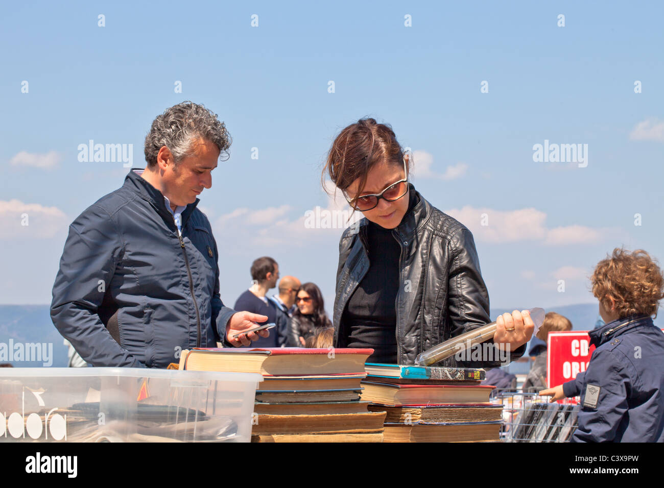 Famiglia guardando vecchi libri nel mercato delle pulci Foto Stock