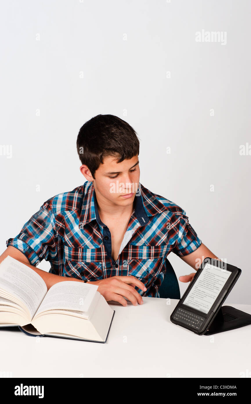 Studente confrontando un libro tradizionale con la sua versione moderna Foto Stock