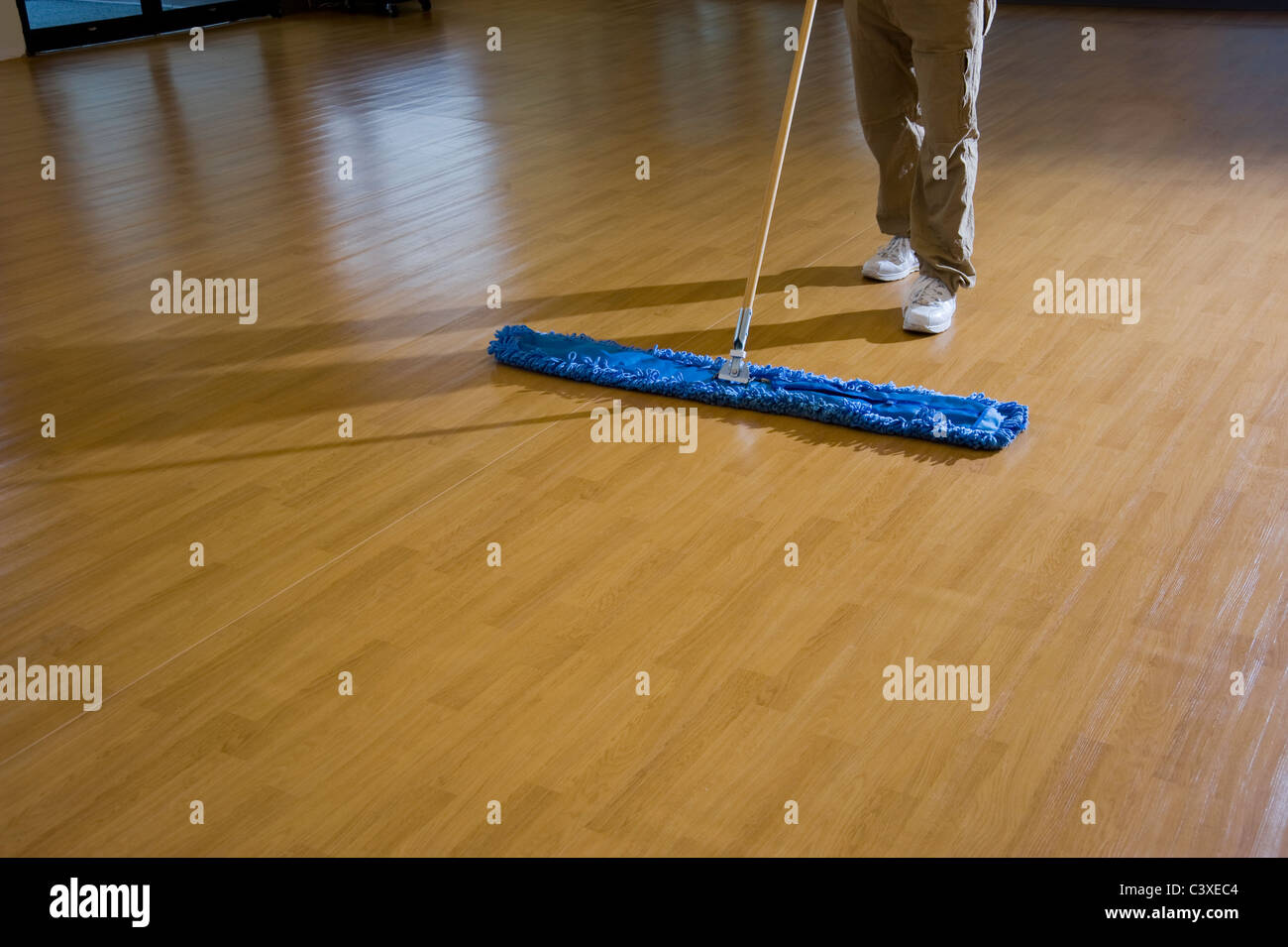 Uomo di pulizia pavimento in legno Foto Stock