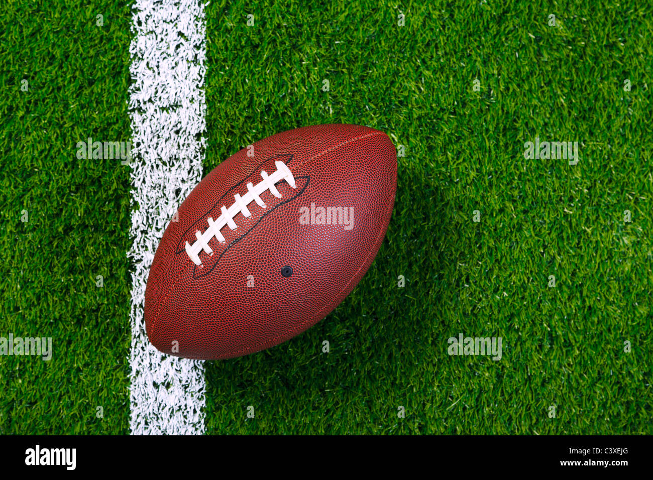 Foto di un american football su un prato accanto al perimetro, ripresa dall'alto. Foto Stock