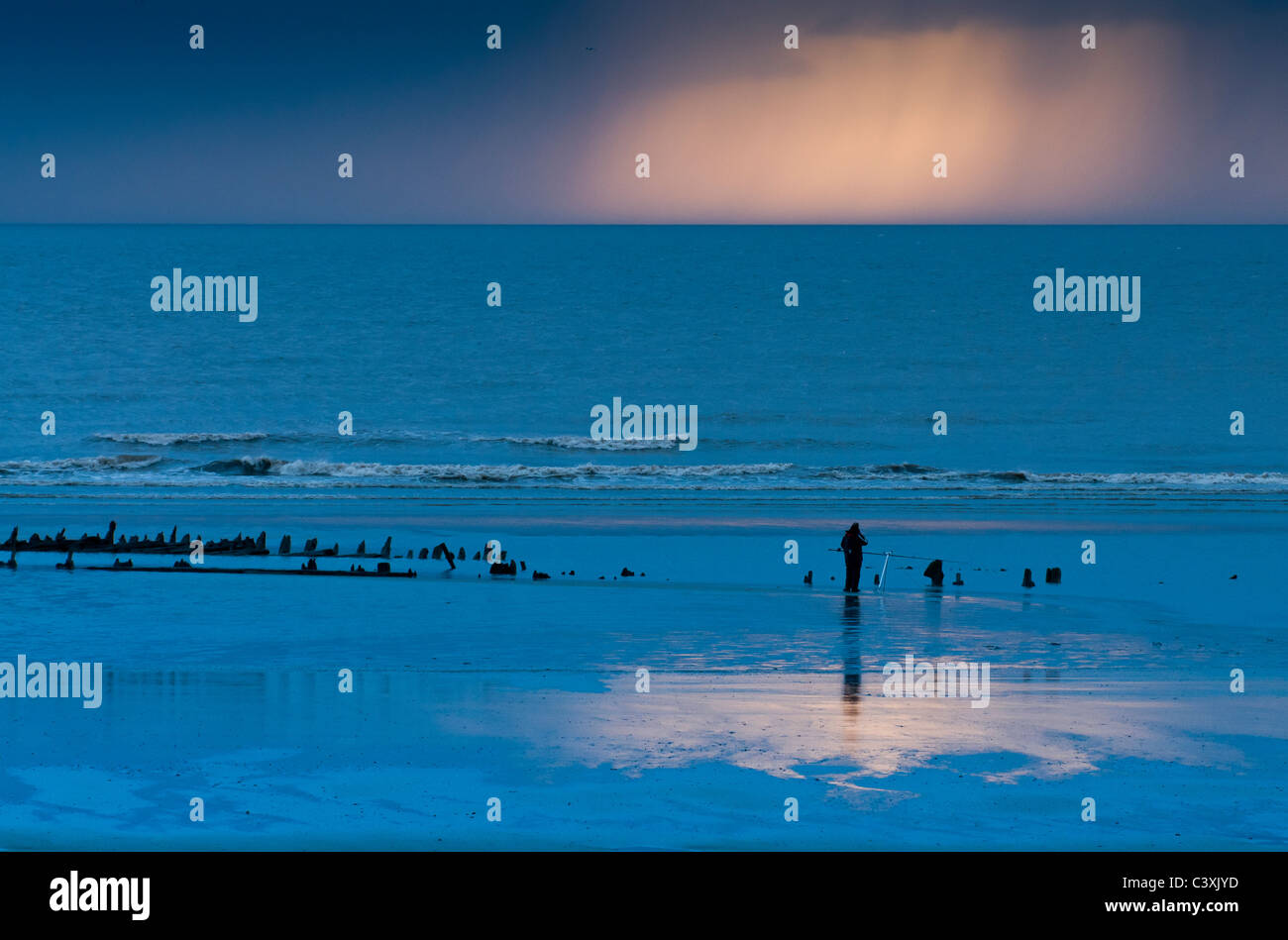 Pescatore sulla spiaggia di notte Foto Stock