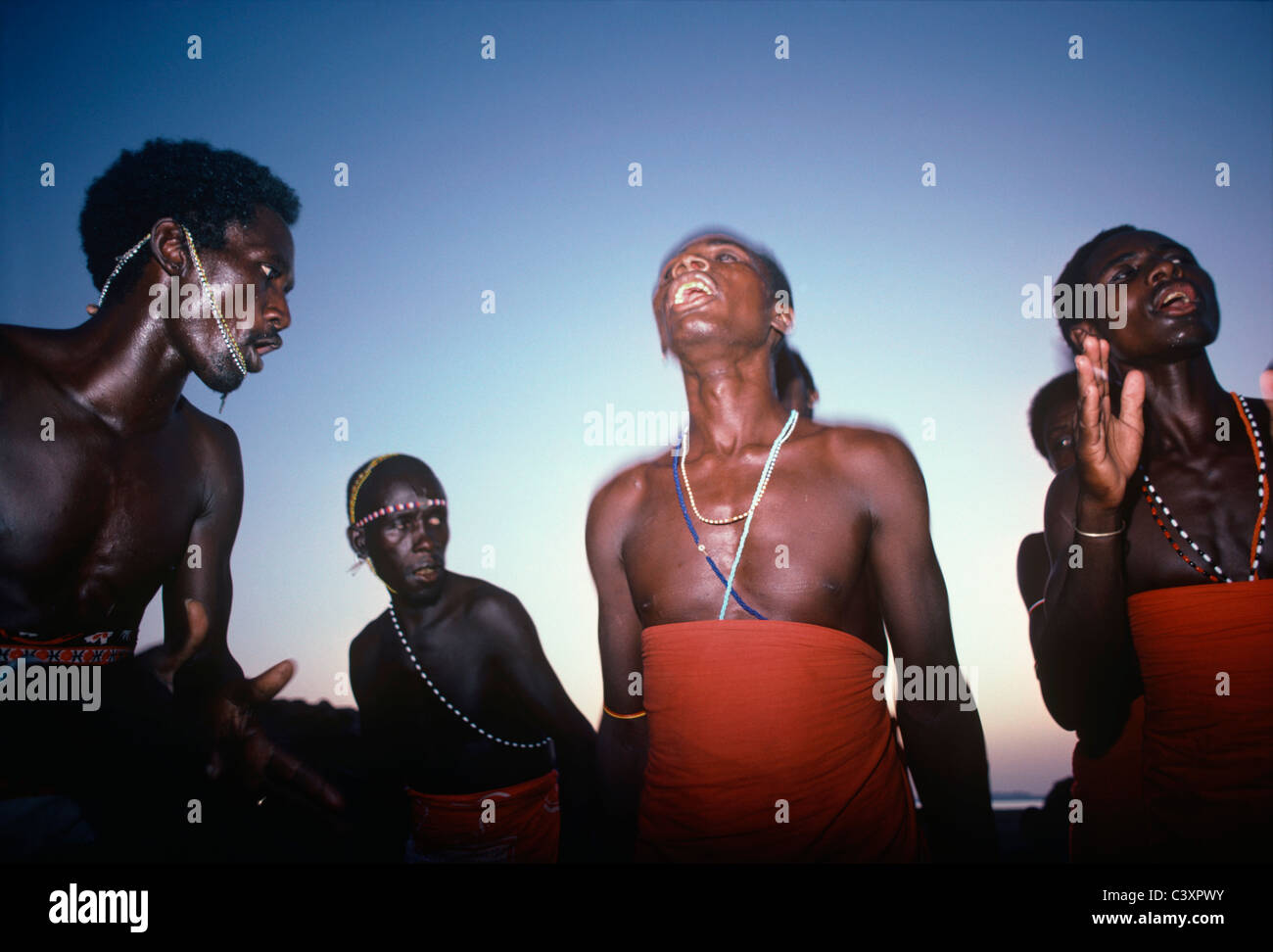 El Molo e guerrieri tribali ballare durante la cerimonia di ippopotamo. Il lago Turkana - Kenya. Foto Stock