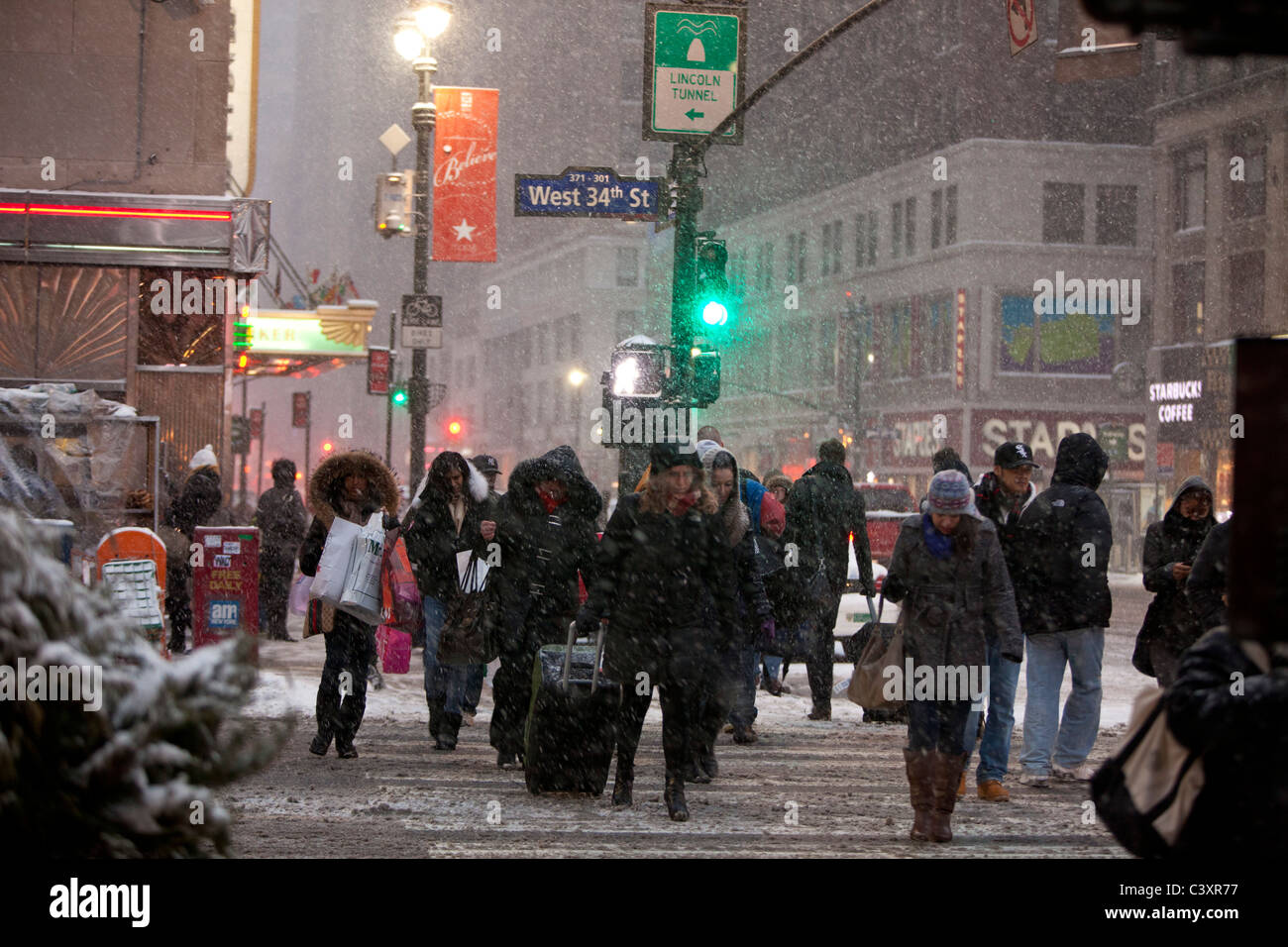 Tempesta di neve, West 34th Street e la 8th Avenue. I viaggiatori rush per arrivare alla stazione di Penn Foto Stock