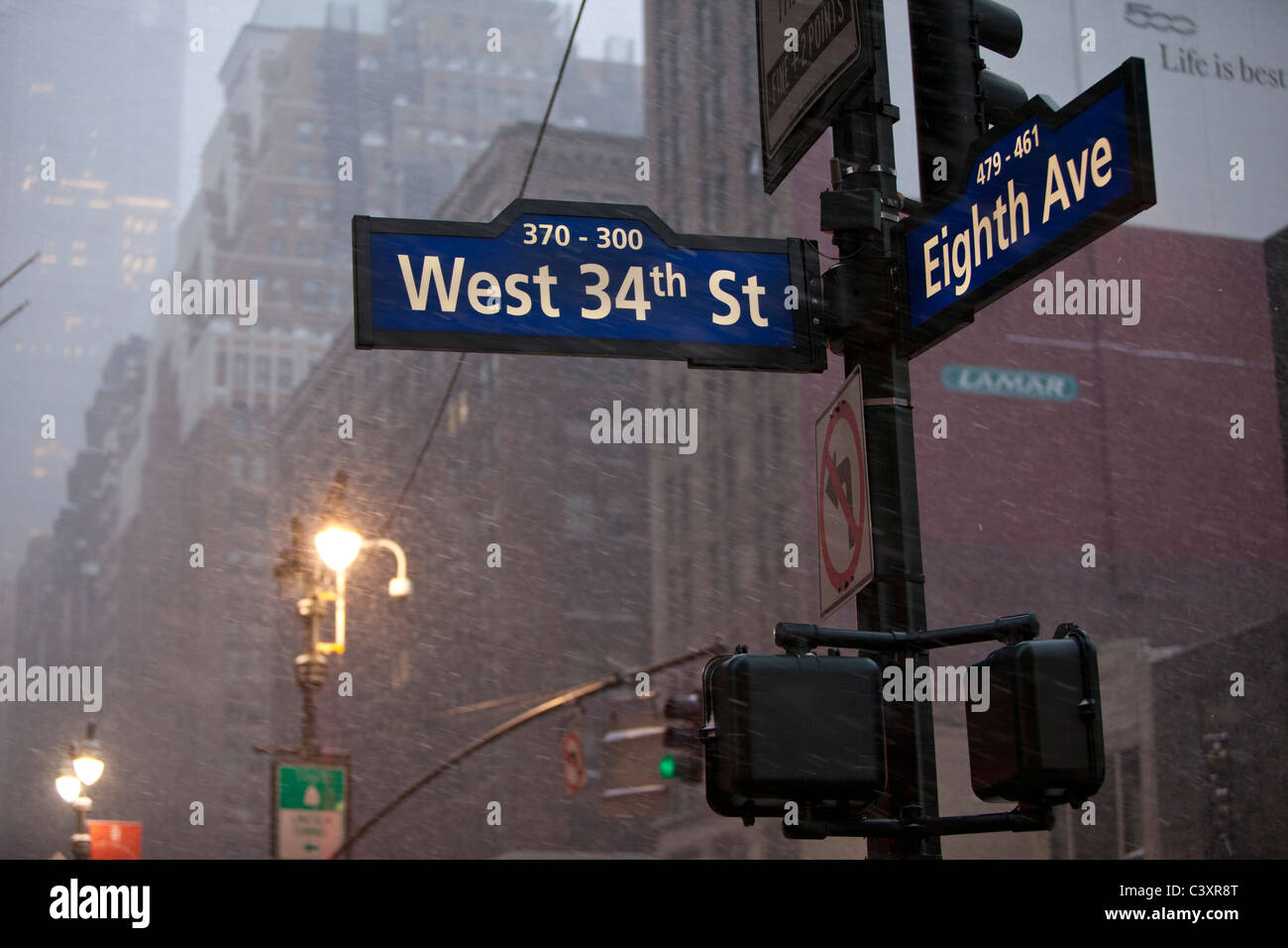 Un cartello stradale a West 34th Street e la 8th Avenue, la neve è caduta pesantemente, tardo pomeriggio invernale, inverno Foto Stock