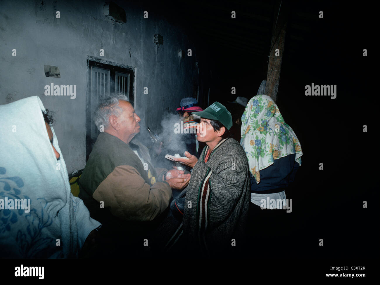 Peruviano guaritore folk (curandero) soffia un mistico polvere bianca nella faccia di un uomo che intendono per purificazione spirituale. Foto Stock