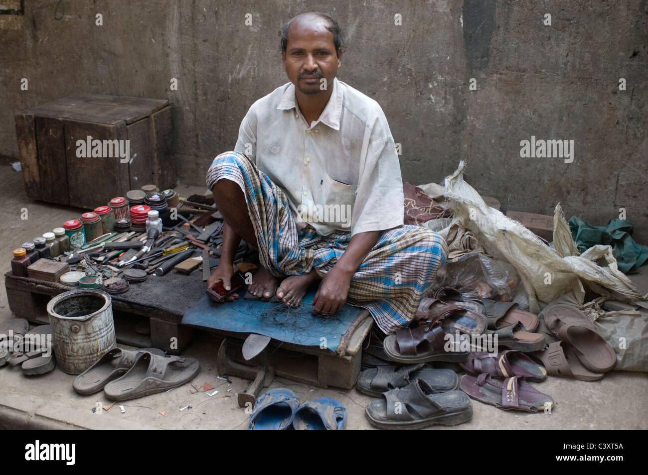 Una calzatura uomo di riparazione nella vecchia Dhaka. Foto Stock