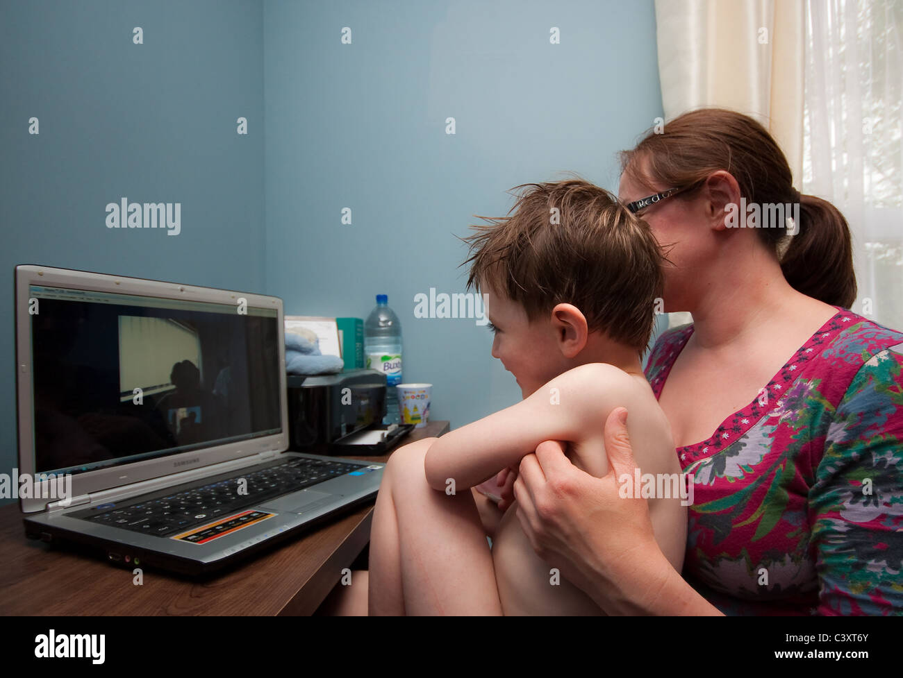 Madre e figlio giovane parlare ai parenti su Skype Foto Stock